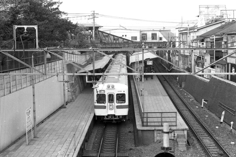 2番目の跨線橋から下北沢駅舎と井の頭線・1番目の跨線橋を望む。通勤電車の車体色がクリーム色に青帯と変化した頃で、急行電車は8両編成であった（1971年4月撮影）。