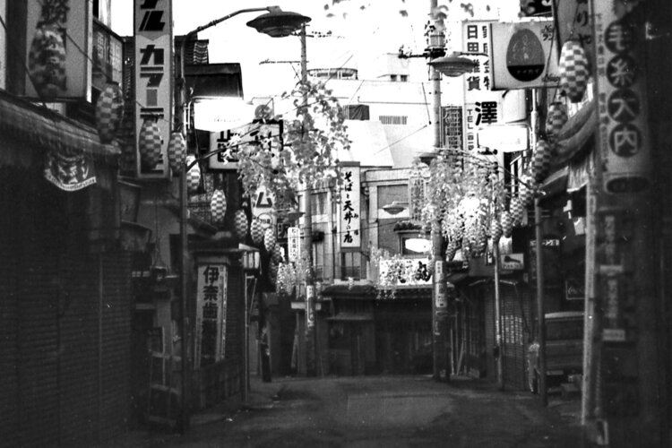 夜明け前の下北沢南口商店街。正面のそば屋「砂場」の右手の坂道を上がると現在の下北沢駅南西口に突き当たる（1969年10月撮影）。