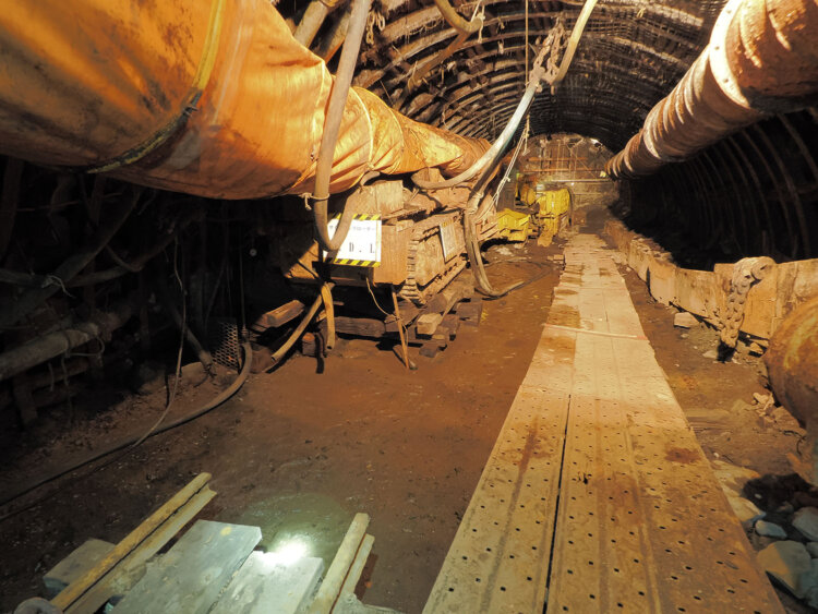 ガイドさんが模擬坑道へ案内する。二股に分岐する坑道とプツっと途切れるレールがいかにも坑内という感じだ。オレンジ色の筒は酸素を送風していた。