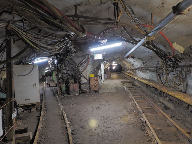 二股で分かれる軌道と坑道。半ば地中に埋もれかけた軌道が坑道内に延びる姿もグッとくる。