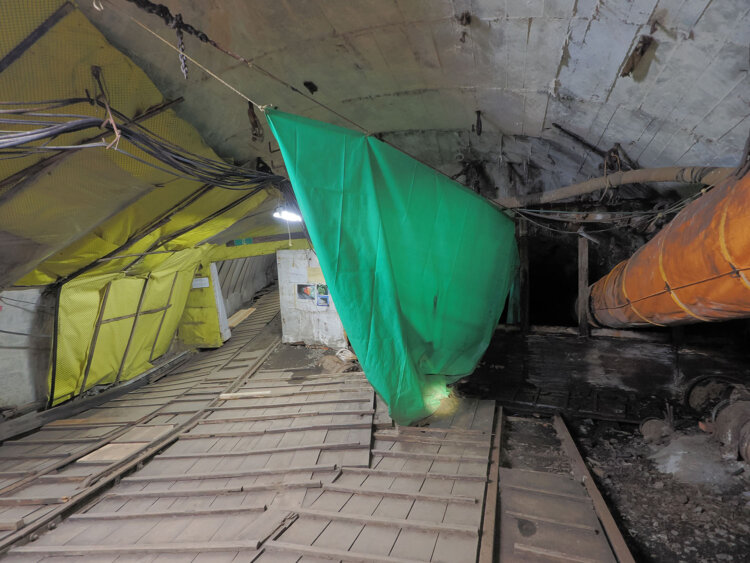 斜坑。水平に見えるがかなりの角度がついている。200ｍ先の明かりが遠くに見える。振り返ると右手は漆黒の闇。斜光の坑道が地中奥深くまで続き、スイッチバックして海底へと延びていた。