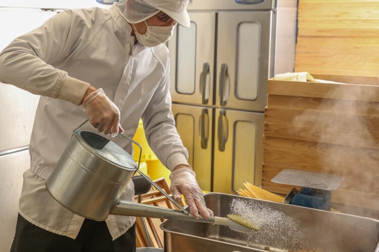 ホクホクの大豆に納豆菌を混ぜる。