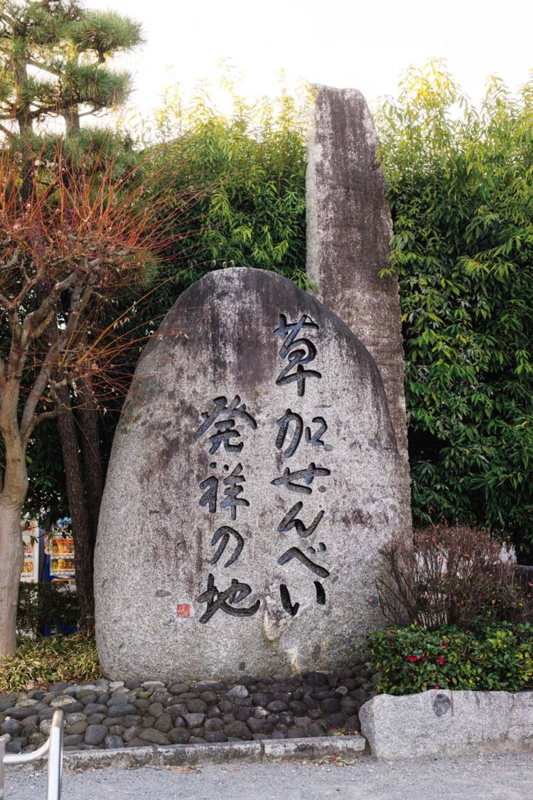 おせん公園に立つ、巨大な「草加せんべい発祥の地」碑。