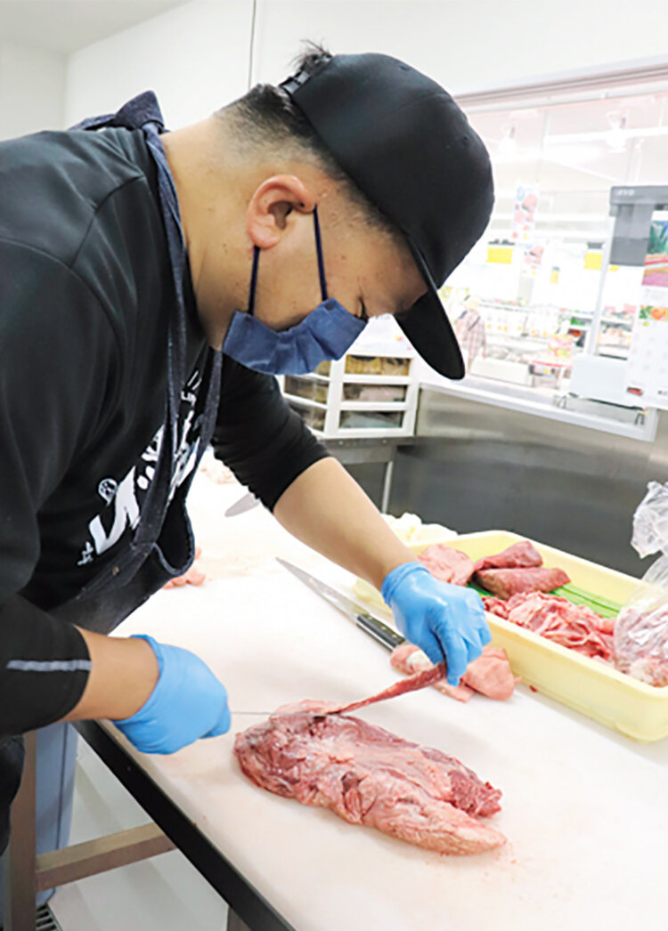 精肉担当の安藤望（のぞむ）さんが店内で枝肉を切り分ける新鮮さが売り。