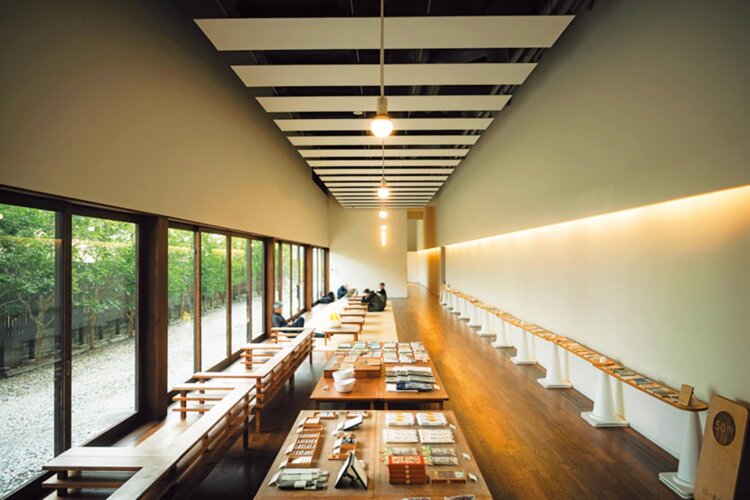 休憩処から窓の外を眺め、ゆったりと思い思いの時間を過ごす。右の壁に延びるのが50m書店。