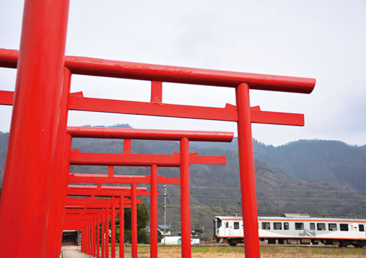 参道を電車が横切る粟津稲生（あわづいなり）神社。