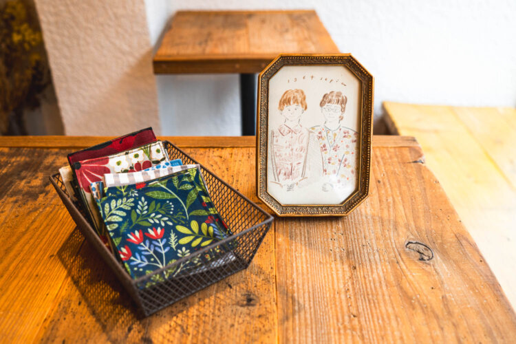 川船さんの伯母さんとお母さんを描いたイラストとお母さん制作のコースター。コースターはお店で使用。550円で販売も。