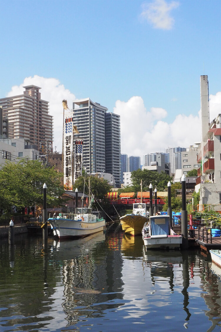 反対側から見た佃堀。写真は佃住吉神社の祭りを控えた頃で、大幟（のぼり）が立っている。