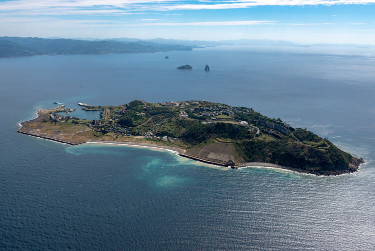 池島を北方向から見る。左手と右手は石炭ガラを捨てた「ボタ山」で、埋め立て地として整備された。写真中心部辺りに当初からの集落であった郷地区がある。