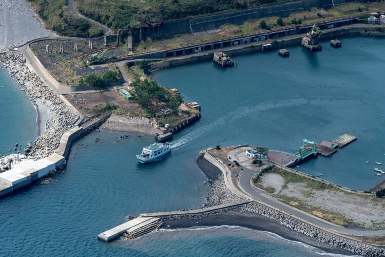 西海沿岸商船のフェリー「かしま」が池島港を後にする。背後は貯炭場跡。撮影時は緑色の「ジブローダー」や石炭船へ積み込む「トリンマー」の姿があった。