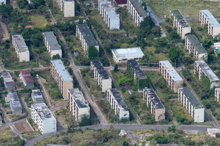 団地群をクローズアップすると、蔦に飲まれる棟やアパート前の広場が木々に埋もれる場所もあって、自然の猛威に驚く。写真中心の低い建物は銭湯であったが閉鎖された。