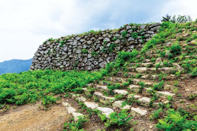 山頂の主郭石垣。有子山稲荷神社参道から登る健脚向け（所要約40分）と、鯵山（あじやま）峠の遊歩道から（約1時間30分）の2つのコースがある。