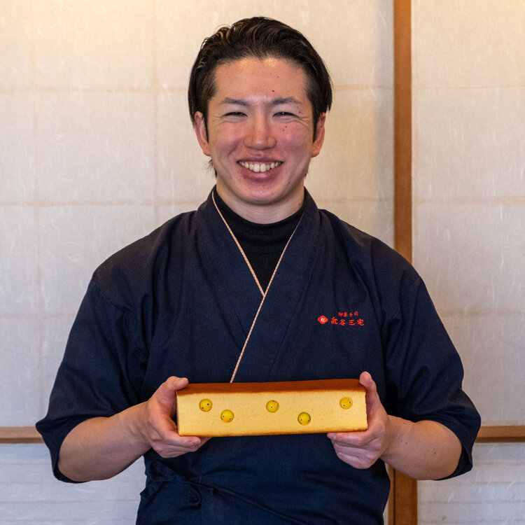 意外な仕掛けを施した訳ありカステラを手にする三宅さん