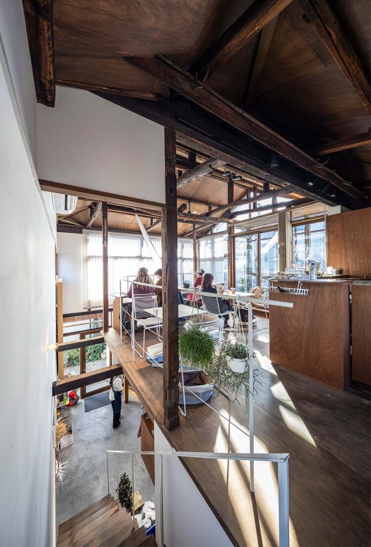 カフェは一部が吹き抜けで、開放的なテラスにつながっている。奥に進むにつれて建物がほぐれていくようなデザイン。