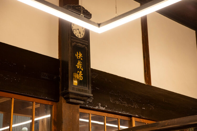 「快哉湯」の文字が入った大きな振り子時計。