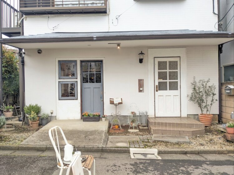 木造アパートの1階に店舗が入っている。右側の白いドアが入り口。
