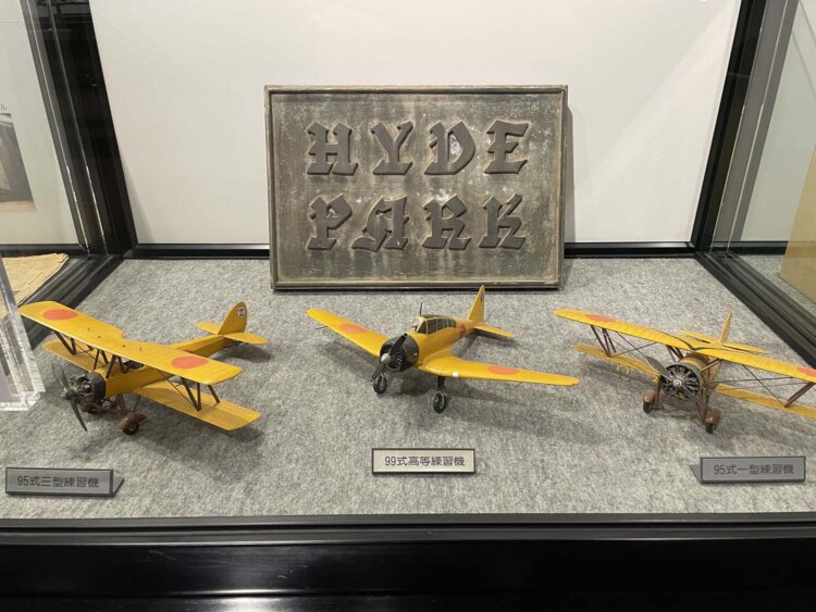 「HYDE PARK」の看板と大日本帝国陸軍の練習機模型。