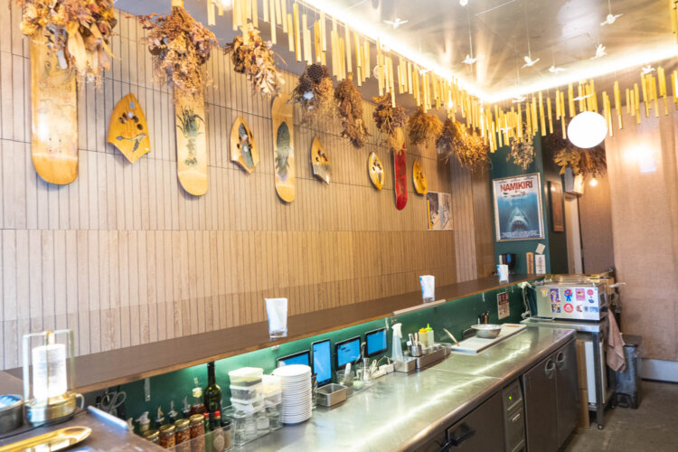 壁にはスケートボードとボディーサーフィンのギアが飾られている。