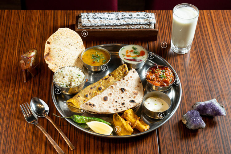 グジャラーティ・ターリー・スーラト・ヌ・ジャマン（グジャラート州スーラト風の大皿料理）4500円。【1】チャーチ（スパイス入りバターミルク）、【2】グジャラーティ・カディ（ヨーグルトとひよこ豆のスープ）、【3】セブ・トマト・ヌー・シャーク（揚げ麺入りトマトカレー）、【4】ラスマライ（チーズとミルクソースのスイーツ）、【5】ダール（豆のスープ）、【6】パパド（豆粉のせんべい）、【7】ジーラ・プラオ（クミンの炊き込みご飯）、【8】メティ・ナ・テプラ（ひよこ豆とフェヌグリークの葉のパン）、【9】チャパティ（全粒粉のパン）、【10】パコラ（野菜の揚げ物）。