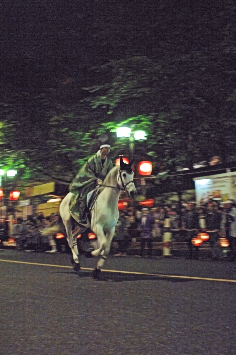 烏帽子と直垂（ひたたれ）姿の騎手が手綱を操り、4頭の馬が旧甲州街道を3往復する。