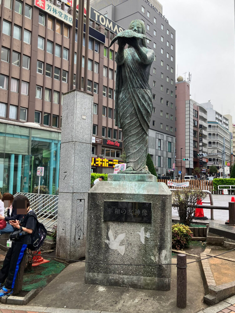 彫刻家・山本豊市作の平和の女神像。1974年の駅前再開発を記念して設置された。鳩を高く掲げるポーズが印象的な像。