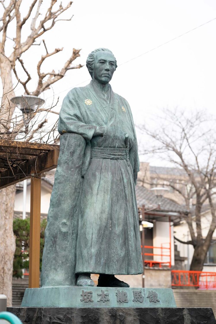 立会川駅そばに立つ、坂本龍馬のブロンズ像。「ざっと歩いて5.8kmのコースぜよ！」。