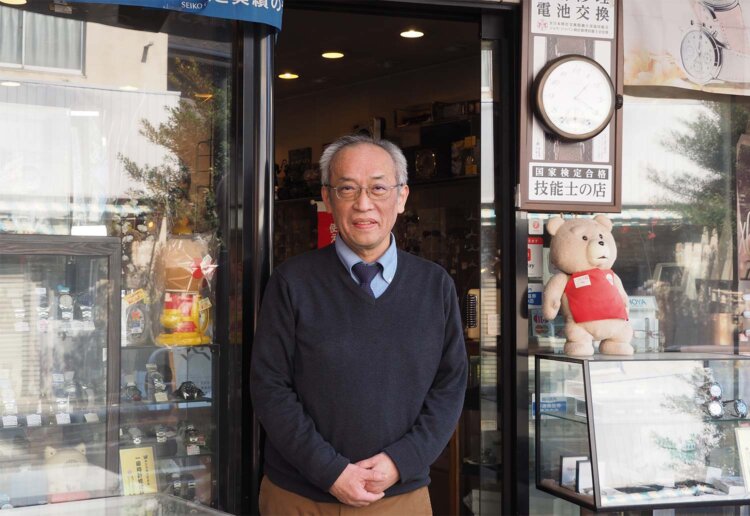 百反通りの中ほどに立つ時計店『タイミーイシバシ』の店主・石橋伸浩さん。