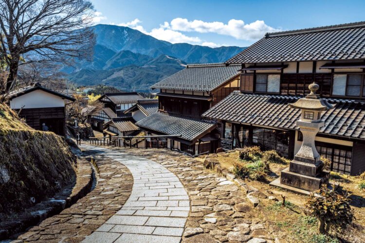 馬籠宿の一番高い場所から見た景色。坂に連なる町並みの奥に恵那山を望む。