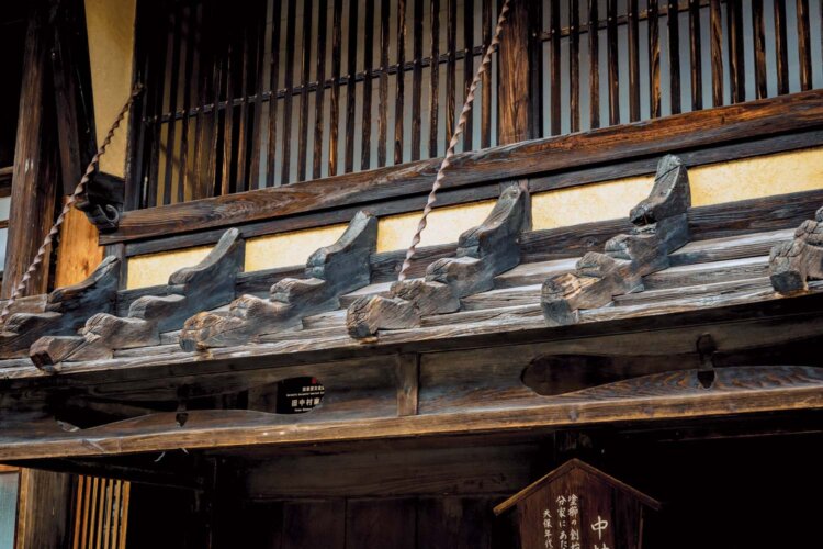 元櫛問屋の建物で、現在は資料館として公開する「中村邸」。2階部分がせり出した出梁（だしばり）造りや板を重ねて葺いた鎧庇（よろいびさし）など、いまも往時の意匠が残る。●奈良井駅から徒歩13分。