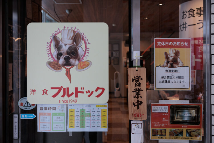 新たなブルドックの絵は敦さんが制作。右奥に見えるのが移転前とほぼ同じ意匠の赤白看板。