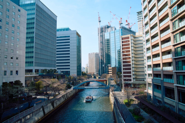 高層ビルに囲まれた目黒川をクルーズ船が行き交う。
