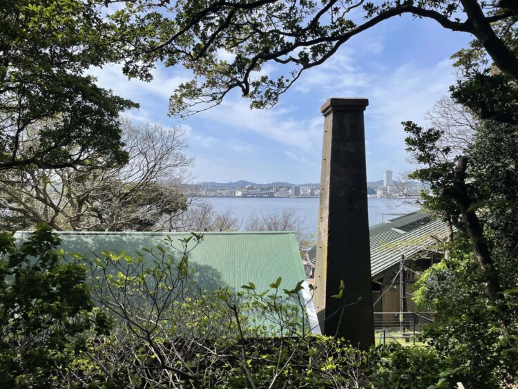 電気灯機関舎（蒸気機関発電所）の煙突。その向こうは海と横須賀中心市街地。