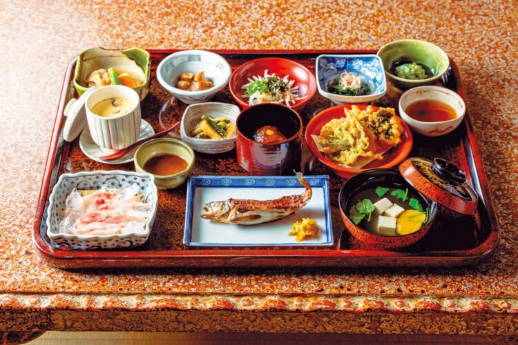 夕食は山の恵みを中心に12品ほどの料理がお膳に並ぶ。この日の食事は岩魚の田楽風や鯉の洗い、野菜の天ぷら、茶碗蒸しなど。吸い物の椀は江戸時代の木曽漆器で、内側の漆を塗り直しながら受け継いできた。