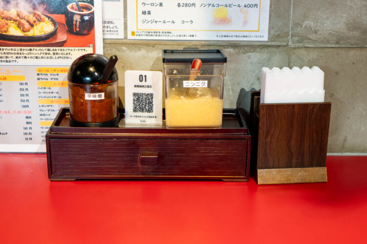 卓上には辛味噌、すりおろしにんにく。そして注文はモバイルオーダー用QRコードから。