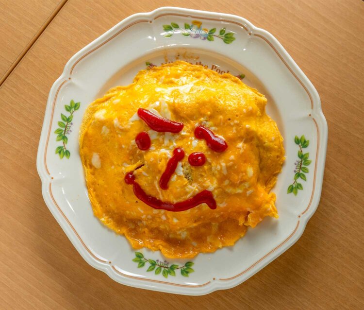 ケチャップで描いた顔がかわいいオムライス1200円は豚肉たっぷり。