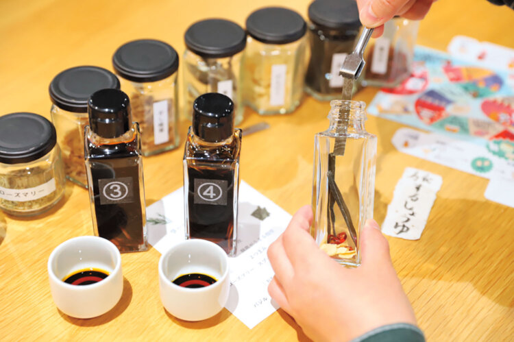 見本で用意された5種類の醤油を参考にオリジナルフレーバーの醤油づくり。醤油の搾りかすを入れた和紙のラベルを貼って完成。