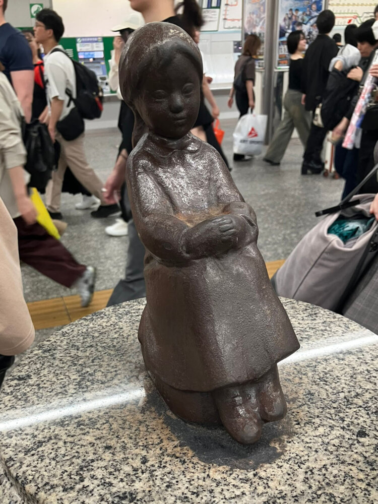 山下公園にある「赤い靴はいてた女の子像」のミニチュア版として制作され、横浜駅に設置された。