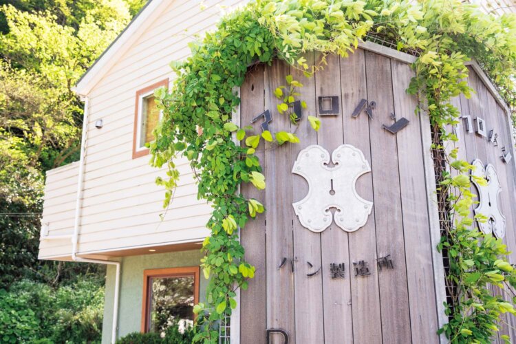 店舗すぐ側の山に溶け込んだ味のある看板が目印。