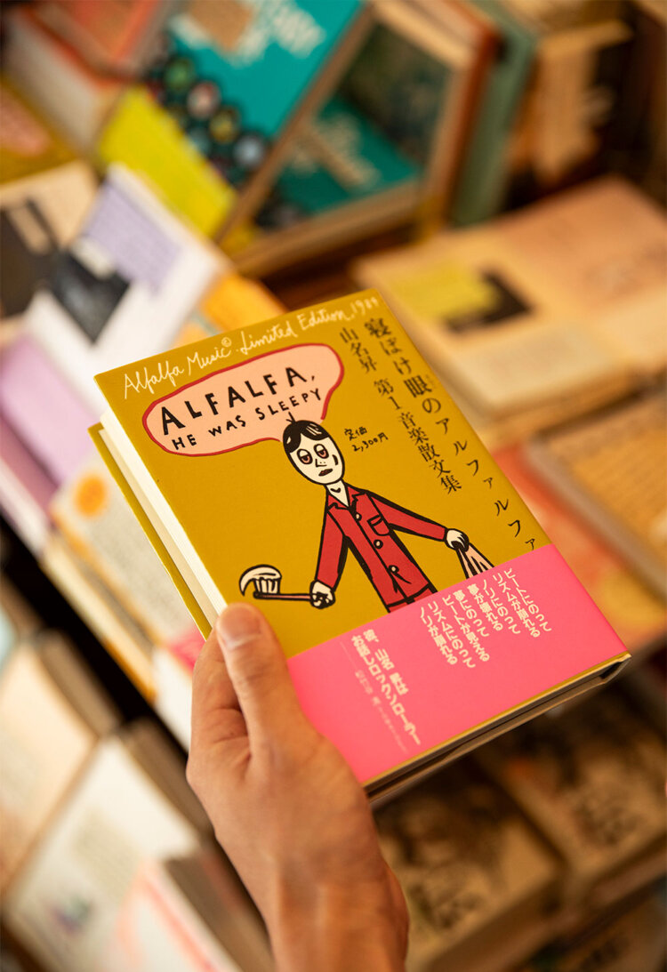 「新刊はうちでしか買えない」と植田さんが手に取る『寝ぼけ眼のアルファルファ』2530円は音楽評論家・山名昇さんの1984年発行の私家版。