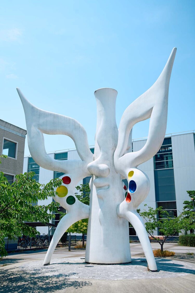 万博記念公園駅東口には、「未来を視（み）る」と万博開催時、作品本体の周囲に置かれていた青い顔と白い顔が。