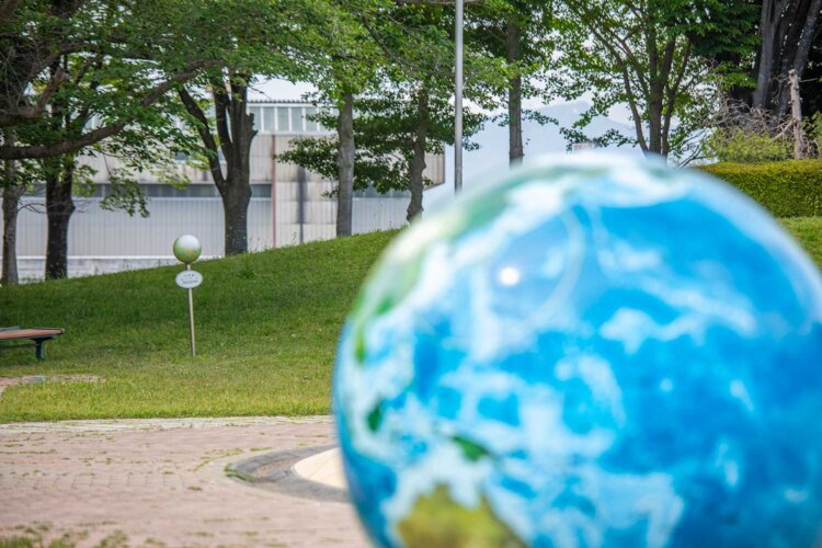 1200万分の1の大きさと距離で再現された地球儀と月球儀。遠くに見える筑波山が太陽の位置になる。