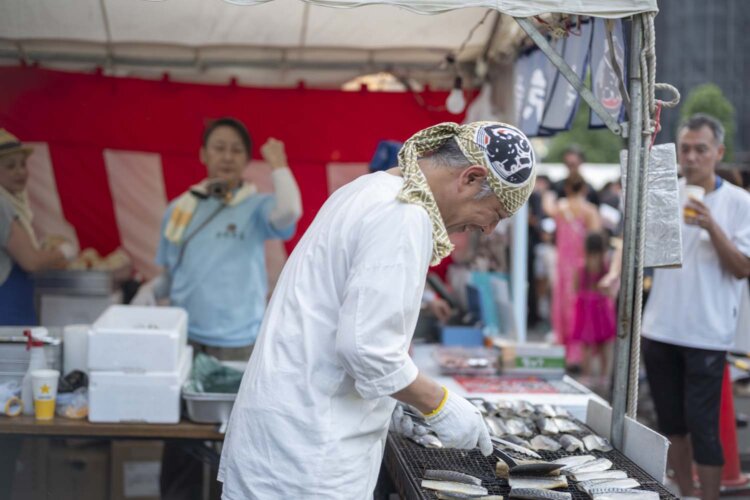 築地本願寺の盆踊り大会では大行列を前に鯖を焼き続ける。