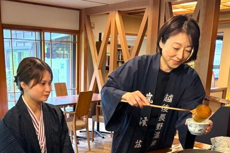 お客さんに源泉のほうじ茶を振る舞う若女将の由香利さん。