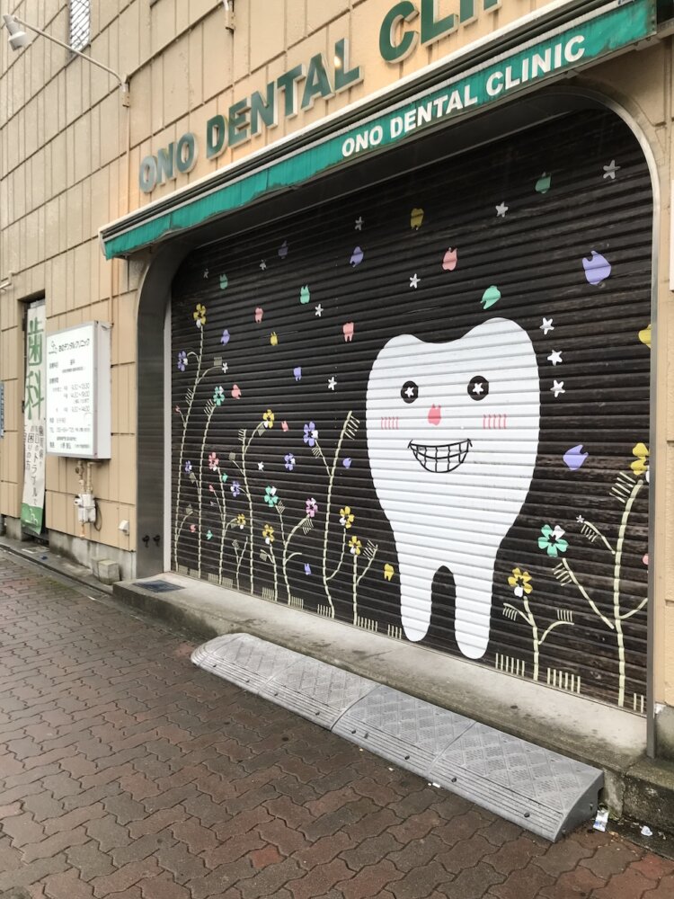 シャッターに描かれた歯。よく見ると植物の葉が歯ブラシ。