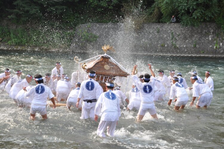 荒川で行われる「神輿洗いの儀」。水しぶきをあげながら神輿を担いで川の中を練り歩く。