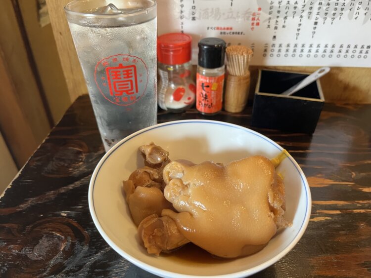 宝焼酎の水割りでいただく豚足煮込み350円。豚足の味付けは西成での経験を生かした。