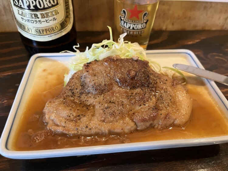 佐藤式トンテキは、ナイフと箸で切り分けながら食べるのも賄い発祥らしいスタイル。濃い味が酔った舌を刺激する。