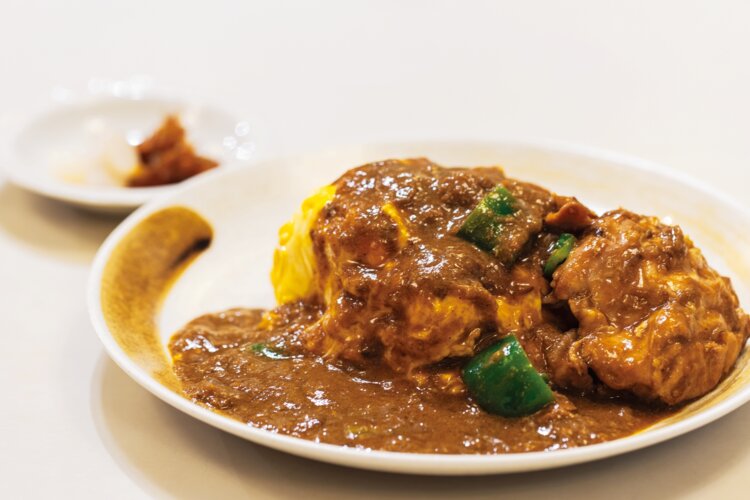 骨付き鶏の出汁のうまみが冴えるふわとろオムカレーライス1300円。鶏肉は塊で添える。