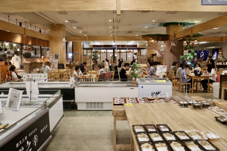 総菜売り場の隣に、薪窯ピッツァの「Comer ＋（コメール プラス）」とイートインスペース。