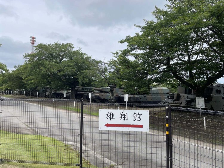 柵の向こうに見える車両屋外展示場。